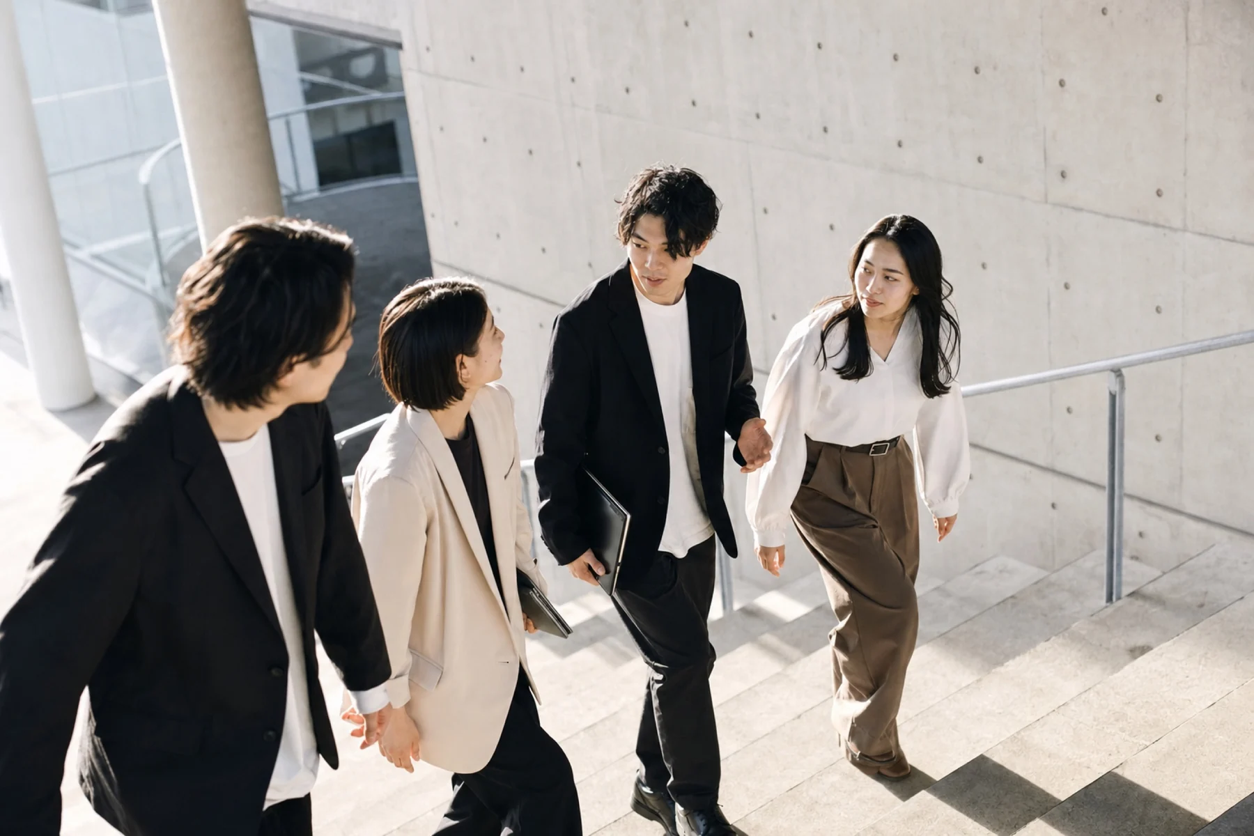 階段を上りながら話す若手チーム